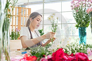 Asian Female florist decorating bouquet of flowers