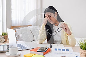 Asian female freelancer headache and stress while working with l