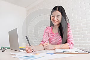 Asian female freelancer working on laptop computer on table at b