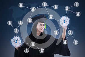 Asian female graduate networking touchscreen