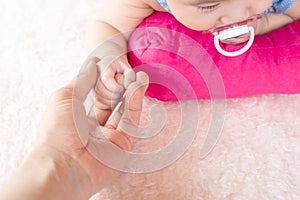 Asian Female hand holding  newborn baby hand. Mom with her child. Maternity, family, birth concept