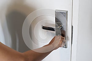 Asian female hand locking white wooden door