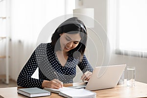 Asian female interpreter in headset translate information from web conference photo