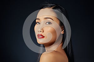 Asian female model with red make up against black background