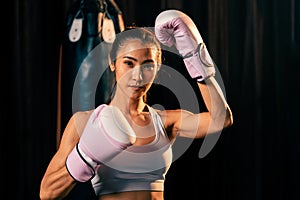 Asian female Muay Thai boxer punch fist in front of camera. Impetus