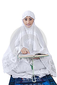 Asian female muslim reading Kuran - isolated