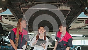 Asian female owner and mechanical worker team, check car undercarriage.