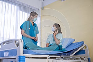 Asian Female Patient Being Reassured By Woman Doctor photo