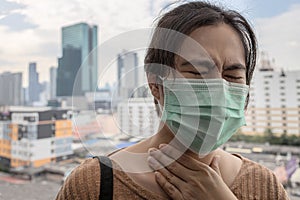 Asian female people coughing touching pain neck with hand,sick woman in face mask,protection of toxic aerosol,air pollution,smog,