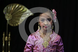 Asian female primary school student dressed in traditional Thai costumes