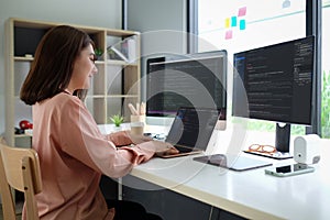 Asian female programmer working at at modern office. Developing programming