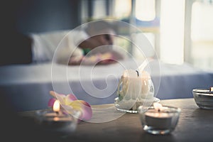 Asian female relaxing in Thai Spa with flower and hot compressed anc candle photo