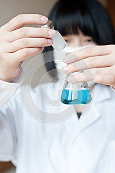 Asian female researcher holding a reagent bottle photo