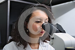 Asian female scientist at microscope