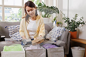 Asian female separate garbage at home. young woman sorting and recycling plastic, paper, aluminum can and food container to trash