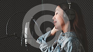 Asian female singer with a passion for music and microphone. While singing recorded in a professional studio Music concept