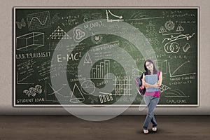 Asian female student standing at written board