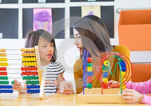 Asian female teacher teaching mixed race kids play toy in classroom,Kindergarten pre school concept