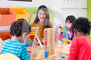 Asian female teacher teaching mixed race kids play toy in classroom,Kindergarten pre school concept