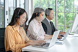 Asian female telemarketer operators, Technical support use headset to call answer client questions in a contact call center