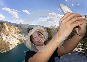 Asian female tourists are taking pictures of themselves at tourist attractions using smartphone