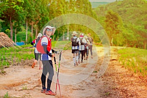 Asian female trail runner wearing sportswear is taking a portrait with a view of a high mountain running track in a dirt road on a