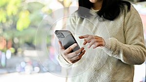 An Asian female using her smartphone. chatting, reading online blog, using mobile app. cropped