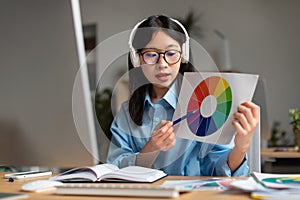 Asian Female Video Calling Choosing Color Showing Paper In Office