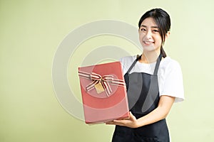 Asian female waitress holding gift box