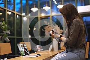 Asian female watching online e-teaching training workshops for camera function by notebook in the living room