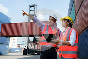 Asian female worker is explaining a check list of container inspections to the supervisor in container depot terminal