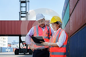 Asian female worker is explaining a check list of container inspections to the supervisor in container depot terminal