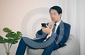 Asian Financial Advisor Thinking and Sit on Bean Bag in Vintage Tone