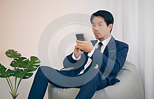 Asian Financial Advisor Touch Smartphone at Home Office in Vintage Tone