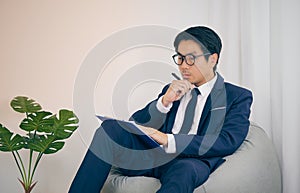 Asian Financial Advisor Wear Glasses Serious Thinking in Vintage Tone_1