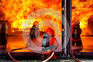 Asian firefighter on duty firefighting, Asian fireman spraying high pressure water, Fireman in fire fighting equipment uniform