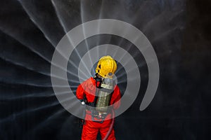 Asian firefighter on duty firefighting, Asian fireman spraying high pressure water, Fireman in fire fighting equipment uniform