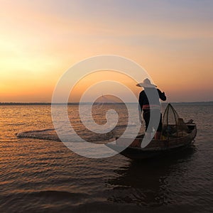 Asian fisherman with his wooden boat going to catching fish