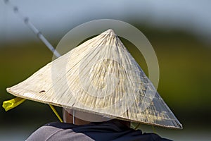An asian fisherman with straw bamboo coolie conical hat
