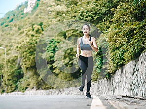 Asian fitness woman runner stretching legs before run