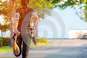 Asian fitness woman runner stretching legs before run outdoor workout in the park.