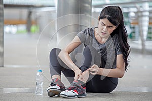asian fitness young woman Running injury leg accident of workout exercising on street in urban city . sport runner girl sitting