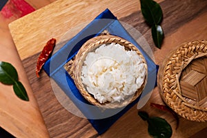 Asian Food concept Glutinous rice or Sticky rice in bamboo wicker on wooden board and black background with copy space