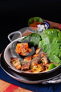 Asian food concept homemade Korean Grilled pork belly BBQ Samgyeopsal-gui with kimchi and shiso and salad on black background with