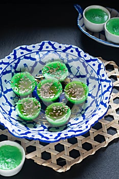 Asian food concept Thai alkaline pandan rice cake in thai pattern ceramic plate on black background with copy space