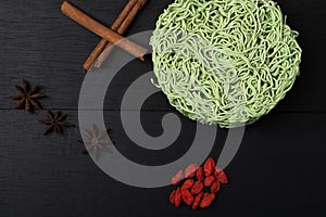 Asian food instant noodle cinnamon anise wolfberry on black wood table