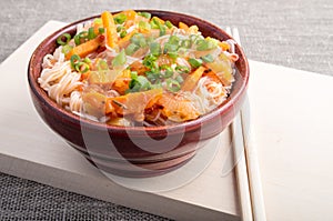 Asian food of rice noodles in a small brown wooden bowl