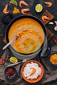 Asian food shrimp in curry sauce, rice and spices.Indian or Thai dish. View from above.