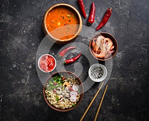 Asian food, Tom Yam and Ramen with shrimps, Thai food in wooden bowl, Egg noodles, Preparation, Chilli peppers, onion and mushroom
