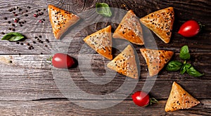 Asian food. Vegetarian samsa samosas with tomato on a wooden board background copy space top view